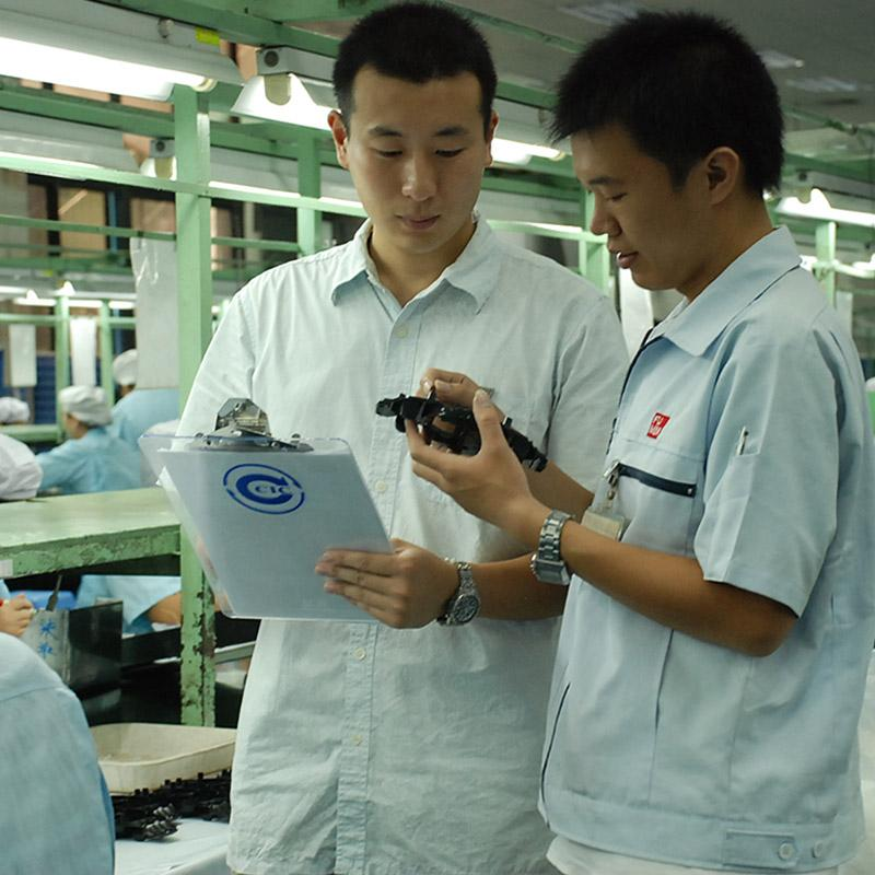 Inspector revisando componentes durante una inspección de calidad en una fábrica china